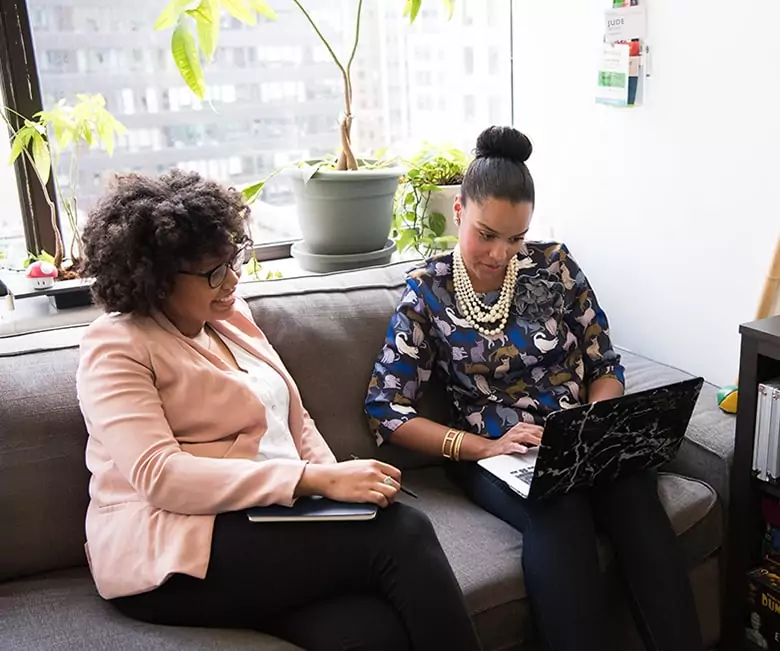 Women discussing business on couch